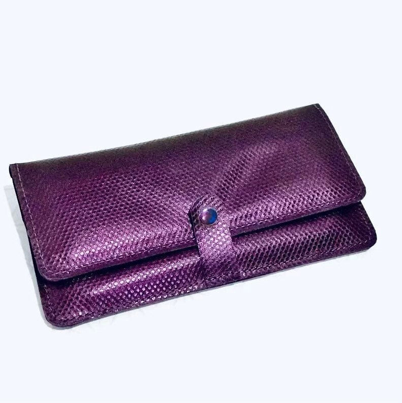 Purple clutch purse with a textured surface on a white background