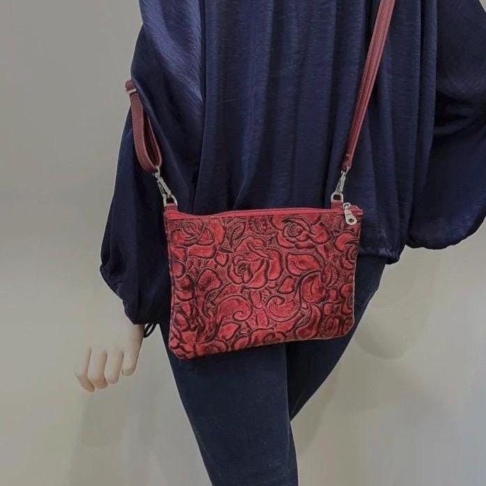 Person wearing a red patterned bag over their shoulder against a plain background