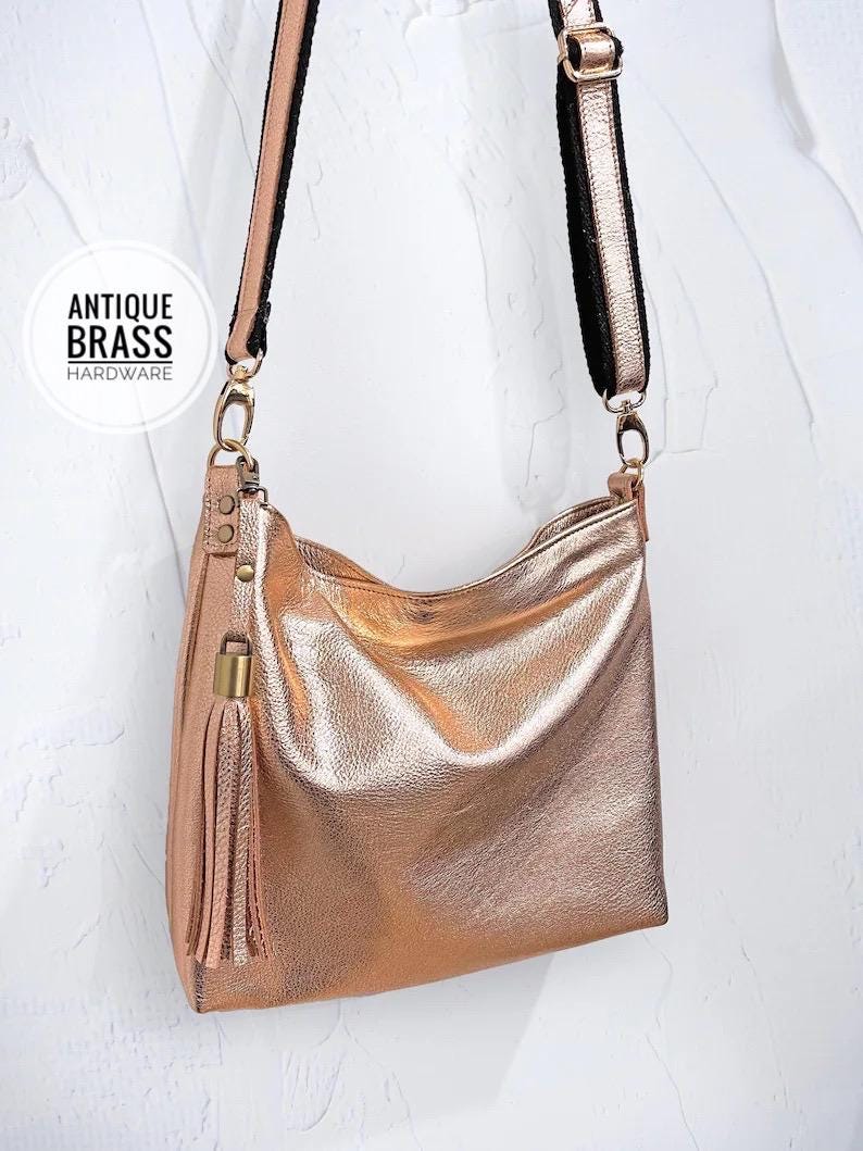 Rose gold handbag with 'Antique Brass Hardware' text on a white background