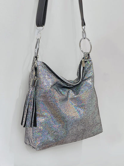 Silver metallic handbag with a tassel and Large O ring feature with black strap on a white background
