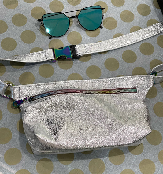 Silver fanny pack with sunglasses on a polka dot background