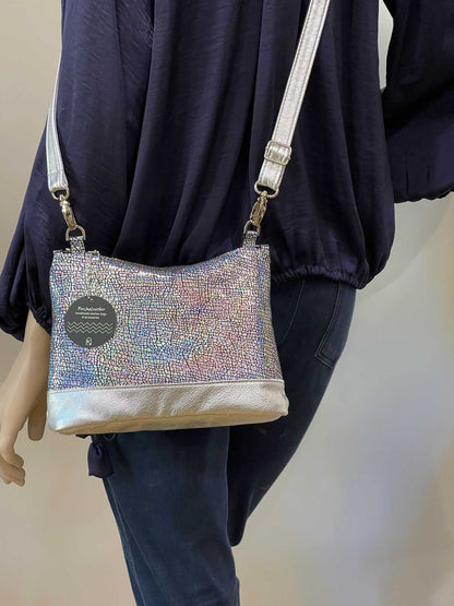Person wearing a sparkly handbag with a neutral background