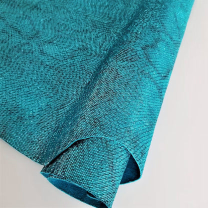 Close-up of teal textured fabric on a light gray background