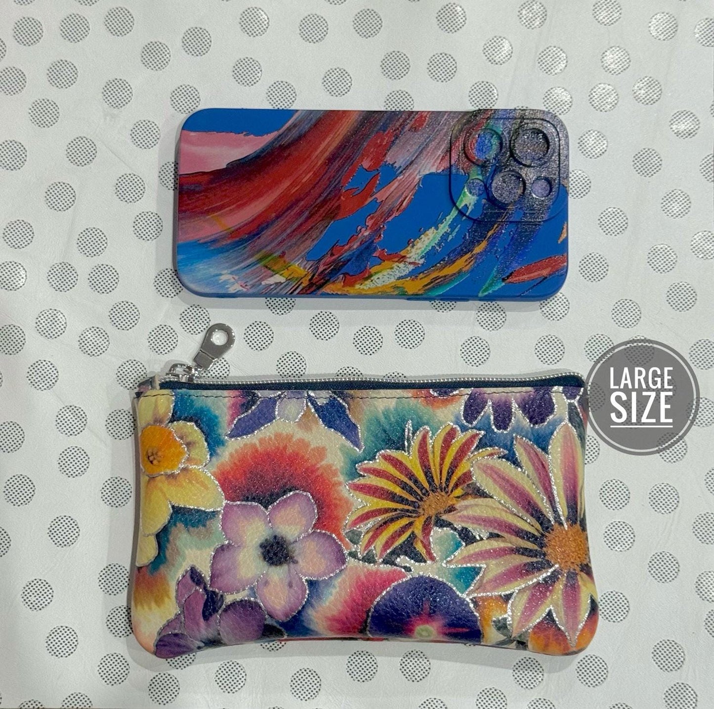 Colorful phone case and floral pouch on a polka dot background