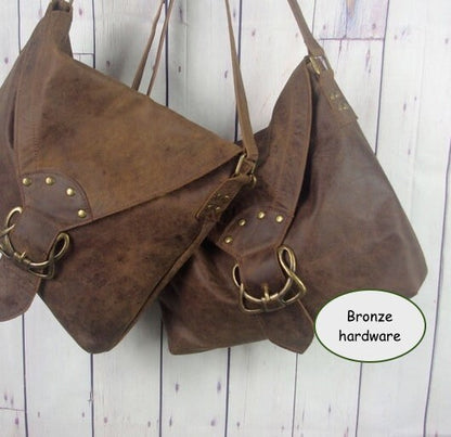 Brown leather handbag with bronze hardware on a wooden background